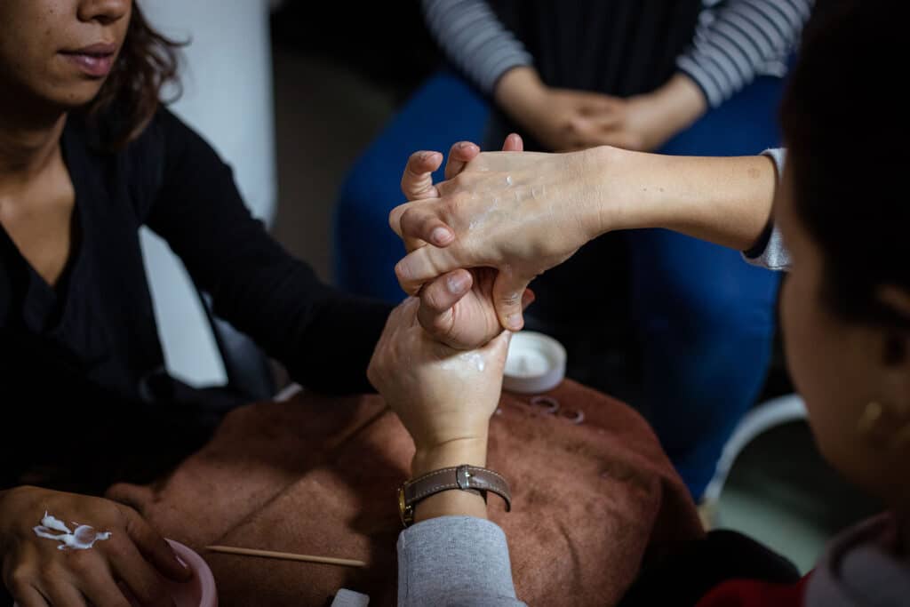 En formation d’esthéticiennes, des mères célibataires s’entraînent à se masser les mains entre elles. Milla Morisson / HansLucas pour La Déferlante
