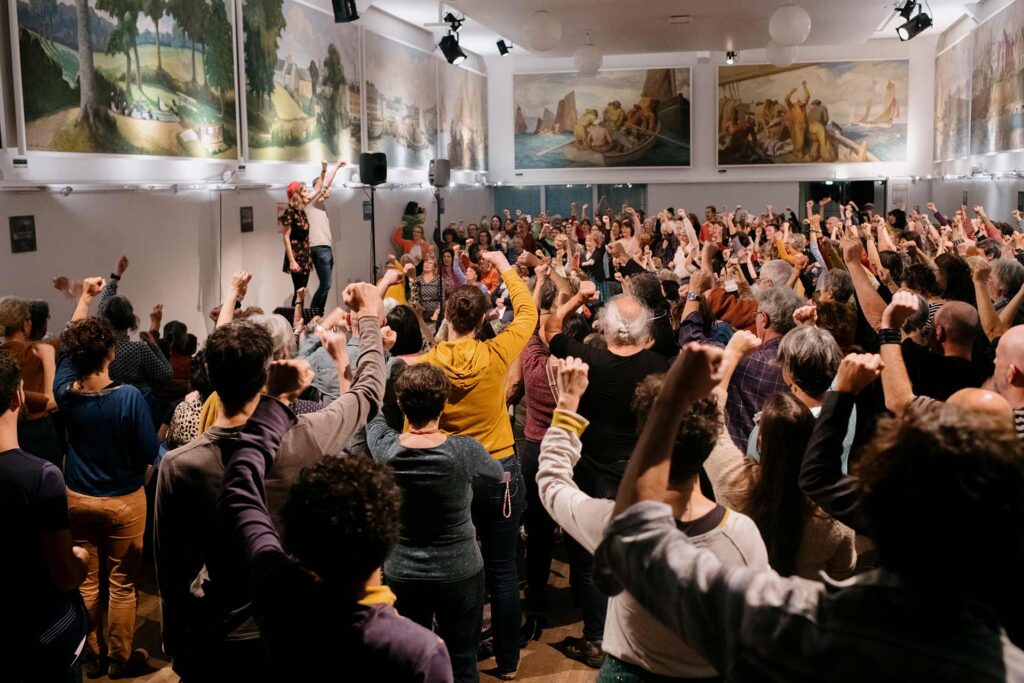 Entre novembre 2024 et janvier 2025, plusieurs initiatives ont commémoré le centenaire de la grève des sardinières de Douarnenez. Ici, 300 personnes sont réunies à la salle des fêtes de la ville pour répéter les chants qui rendent hommage aux 2 000 ouvrières qui se sont mobilisées avec succès pour de meilleurs salaires.