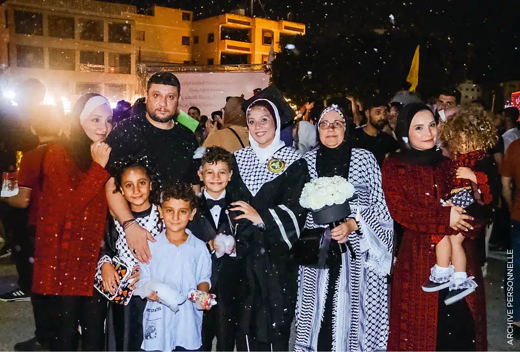 Le 23 août 2023, dans la ville de Gaza. Aya Mghames, entourée de sa famille, vient de recevoir son diplôme en sciences économiques. Sa mère Wafaa se tient à côté d’elle, et sa nièce Joury est la première des enfants à gauche. Depuis avril 2024, la famille est séparée : Aya s’est réfugiée au Caire en Égypte, Joury vit avec ses parents et ses frères près d’Angers en France. Wafaa a, pour sa part, décidé de rester en Palestine avec son plus jeune fils. Archive personnelle. Le 23 août 2023, dans la ville de Gaza. Aya Mghames, entourée de sa famille, vient de recevoir son diplôme en sciences économiques. Sa mère Wafaa se tient à côté d’elle, et sa nièce Joury est la première des enfants à gauche. Depuis avril 2024, la famille est séparée : Aya s’est réfugiée au Caire en Égypte, Joury vit avec ses parents et ses frères près d’Angers en France. Wafaa a, pour sa part, décidé de rester en Palestine avec son plus jeune fils. Archive personnelle.